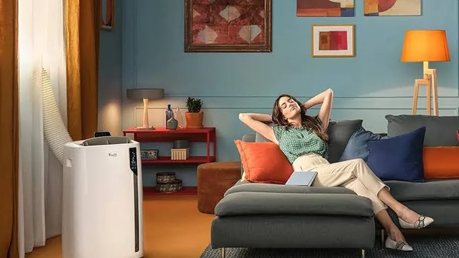 Climatiseur mobile en fonctionnement dans un salon, usage domestique quotidien