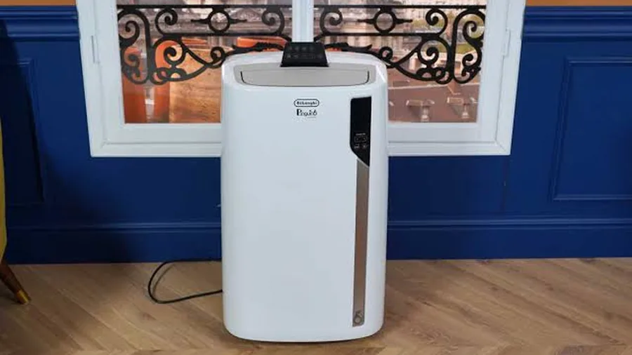 Climatiseur mobile De'Longhi Pinguino placé devant une fenêtre d'appartement